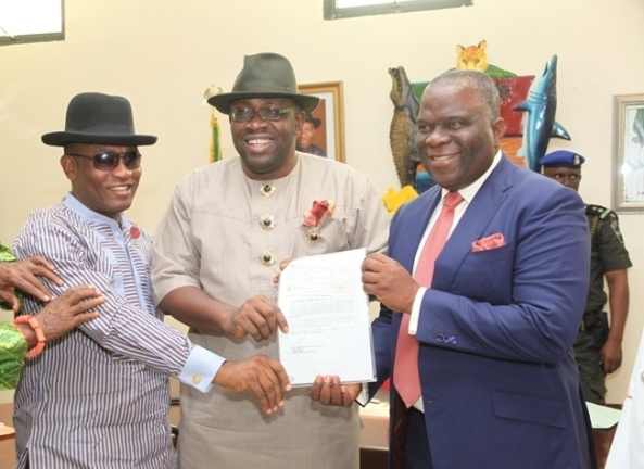 Bayelsa State Governor, Hon. Seriake Dickson (centre) supported by his Deputy, Rear Admiral Gboribiogha John Jonah (Rtd) (left) handing over a draft donation for the sum of N500m from Dr. Mike Adenuga to the Chairman of the newly inaugurated Flood Committee, Gen. Andrew Owoye Azazi (Rtd) at Government House in YenagoaPhoto by Lucky Francis, Government House, Yenagoa